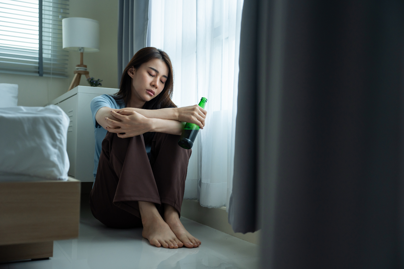 depressed woman drinking on the floor - mental health and addiction dual diagnosis