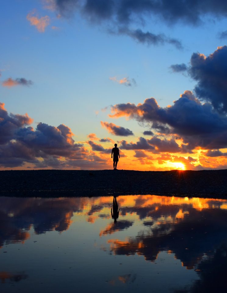 man standing at lake or beach at sunset with water reflecting the sky - alcohol addiction intervention - alcohol intervention specialist